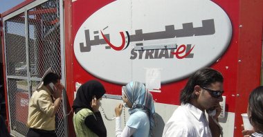 Lebanese refugees at the Syrian-Lebanese border crossing at Jdaidet Yabous talk with their relatives in Lebanon through mobile phones provided free by Syrian telecommunication company Syriatel, July 25, 2006. (AP Photo)