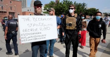 Armed men, one carrying a "The Boogaloo stands with George Floyd" sign, are seen in Detroit, Michigan, U.S. in this undated photo. (Reuters Photo)