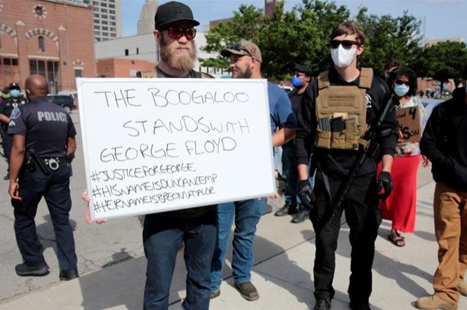 Armed men, one carrying a "The Boogaloo stands with George Floyd" sign, are seen in Detroit, Michigan, U.S. in this undated photo. (Reuters Photo)