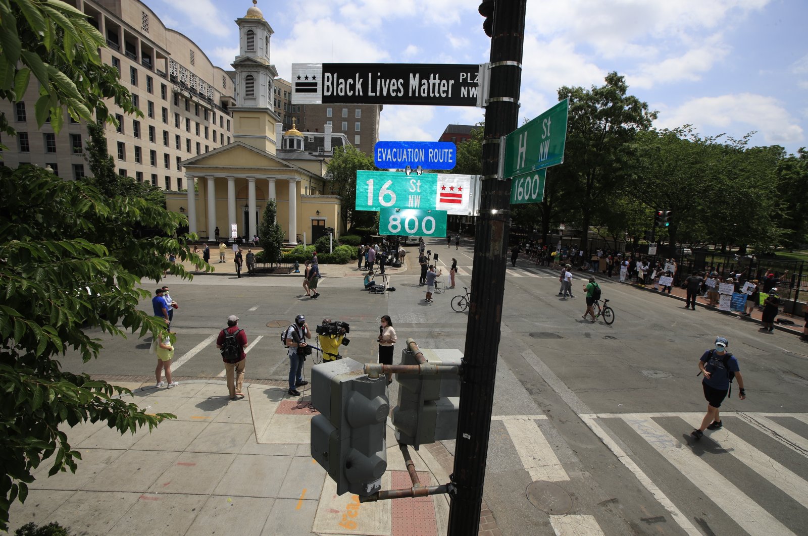 With St. John's Church in the background, people walk under a new street sign, Washington D.C. June 5, 2020. (AP Photo)