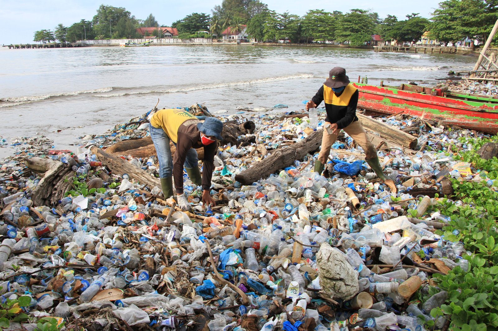 Workers clean up trash at a beach during World Environment Day in West Aceh, Aceh Province, June 5, 2020. Antara Foto/ Reuters.