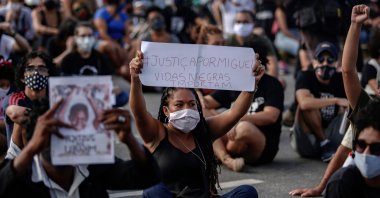A woman holds a sign reading "Justice for Miguel. Black Lives Matter" during a demonstration in demand of justice for the death of five-year-old Miguel da Silva, the son of a black maid who on June 2 fell from the ninth floor of a building while under the watch of his mother's white employer, in Recife, Pernambuco State, in northeastern Brazil, on June 5, 2020. (AFP Photo)