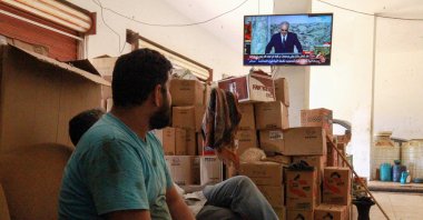 Libyan mechanics watch a televised speech by putschist Gen. Khalifa Haftar, during the talks dubbed the "Cairo declaration" at their shop in the eastern Libyan port city of Benghazi on June 6, 2020. (AFP Photo)