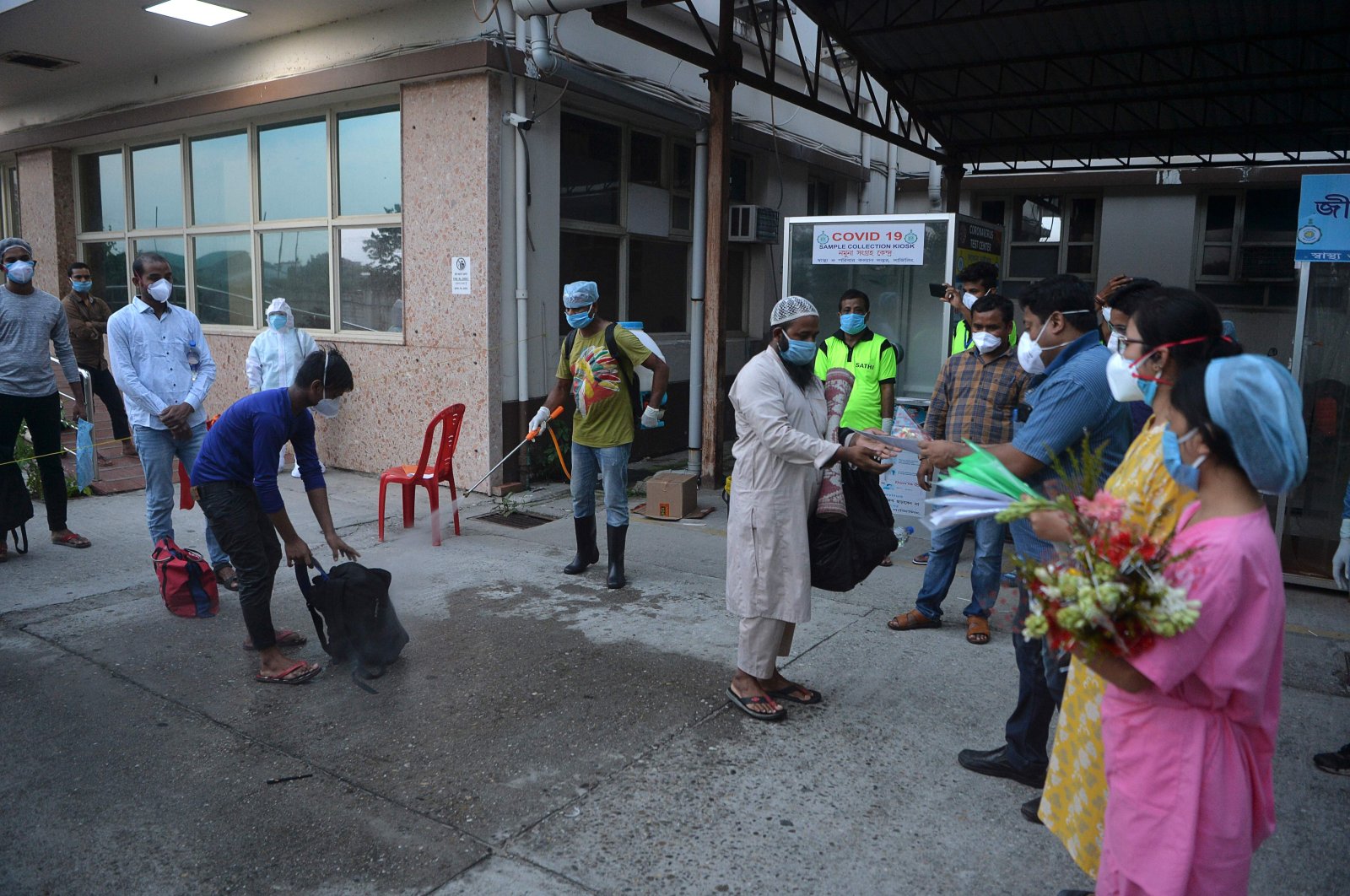 Recovered COVID-19 patients collect certificates from hospital staff as they leave a hospital in Siliguri on June 2, 2020. (AFP Photo)