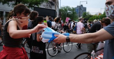 Face masks are handed out as hundreds of protesters march in downtown Brooklyn over the killing of George Floyd by a Minneapolis Police officer on June 5, 2020, in New York City, New York, U.S. (Getty Images/AFP)