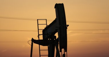 An oil pump works at sunset in the desert oil fields of Sakhir, Bahrain, April 16, 2016. (AP Photo)