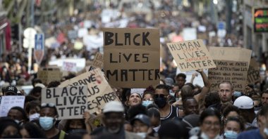 A protester looks up at a sign that reads "Black Lives Matter" in Marseille, southern France, during a protest against the recent death of George Floyd, June 6, 2020. (AP Photo)