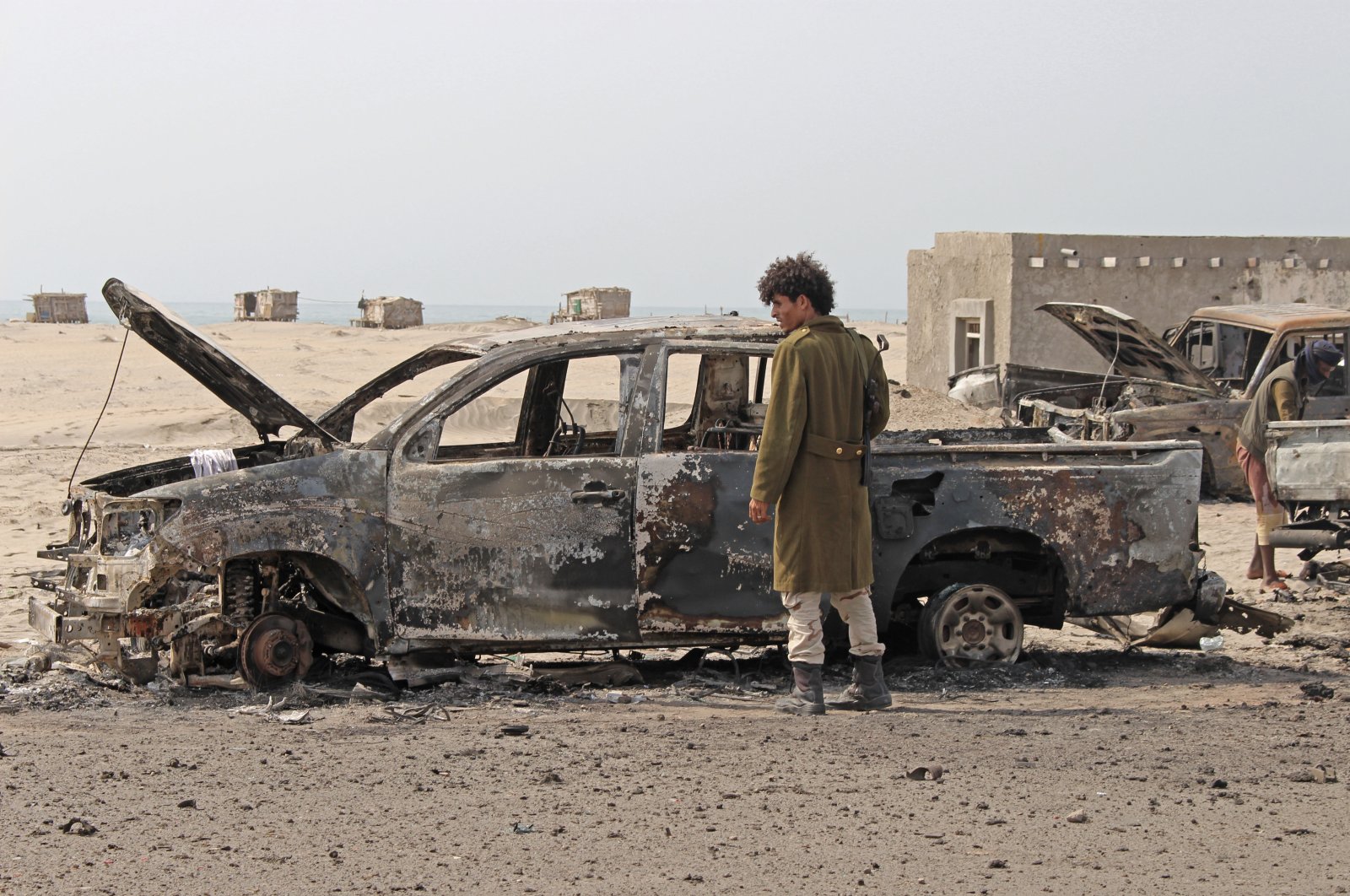 A Yemeni southern separatist fighter inspects the wreckage of government forces vehicles destroyed by UAE airstrikes, Aden, Aug. 30, 2019. (AP Photo)