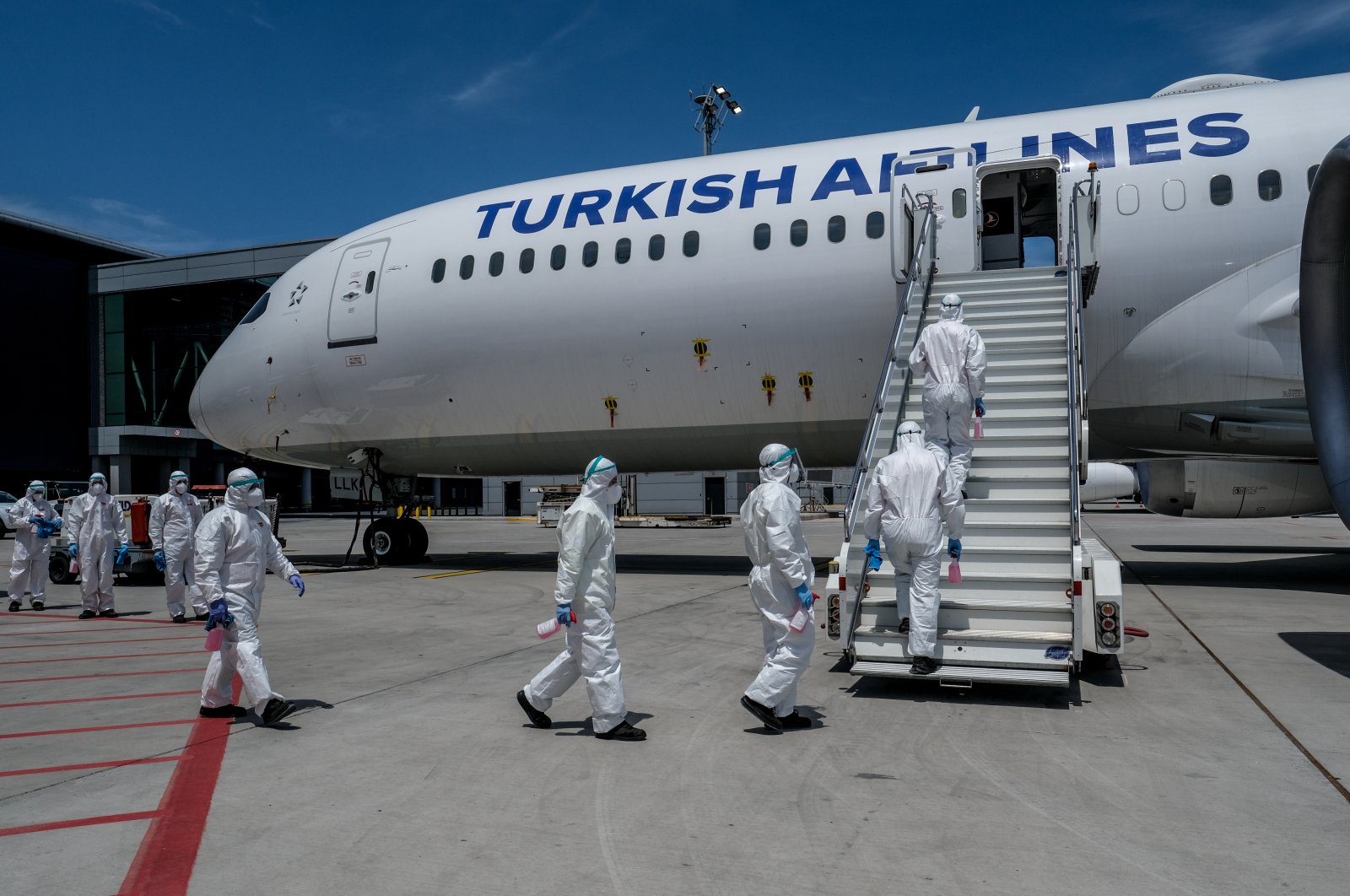 Workers enter a Turkish Airlines plane for disinfection in Istanbul, Turkey, June 2, 2020. (PHOTO BY UĞUR YILDIRIM)