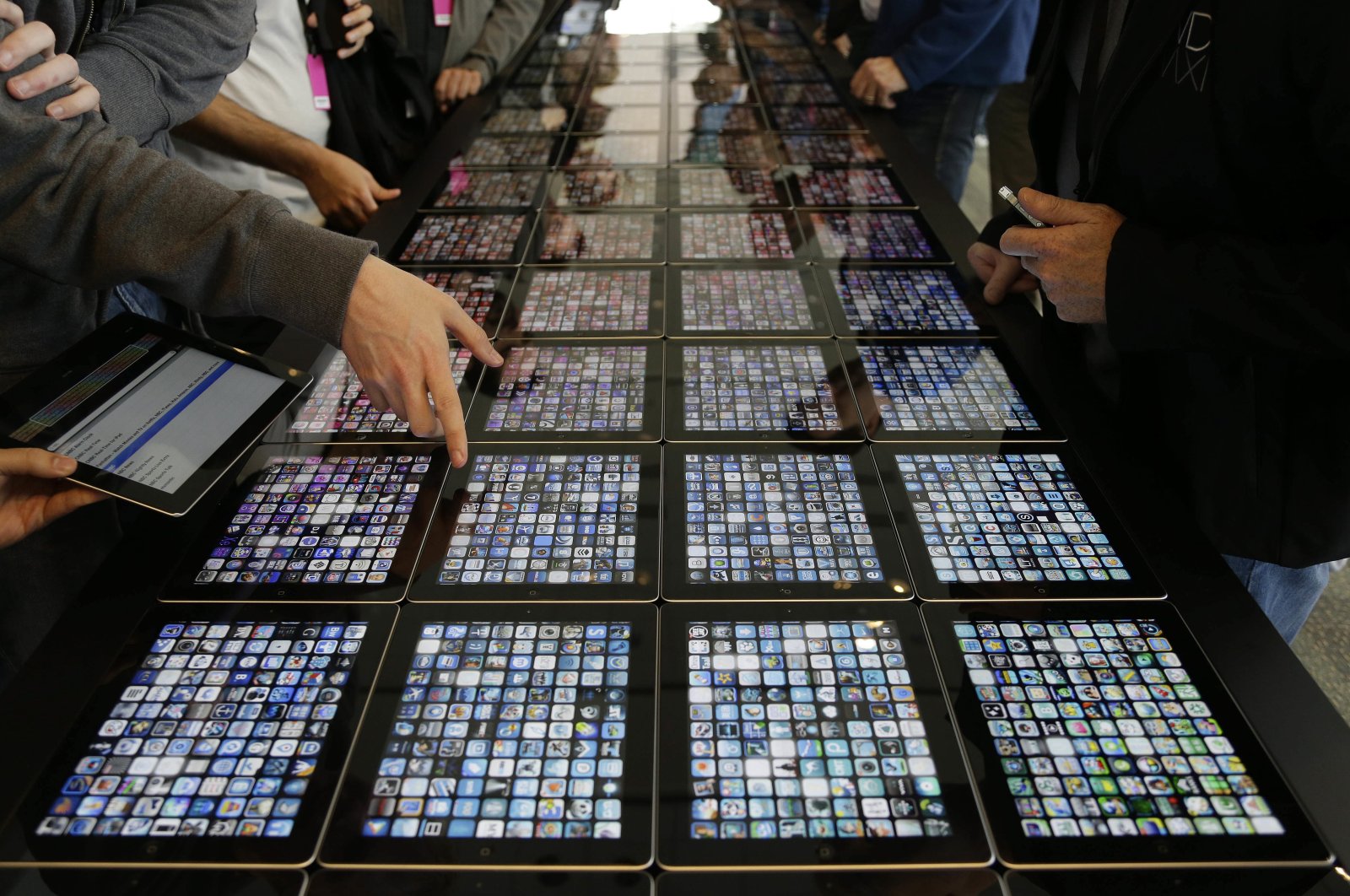 Developers look over new apps being displayed on iPads at the Apple Worldwide Developers Conference in San Francisco, California, U.S., June 10, 2013. (AP Photo)