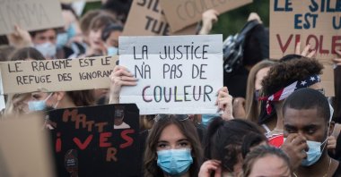 A woman wearing a protective face mask holds a placard reading "Justice has no color," Nantes, France, June 8, 2020. (AFP Photo)