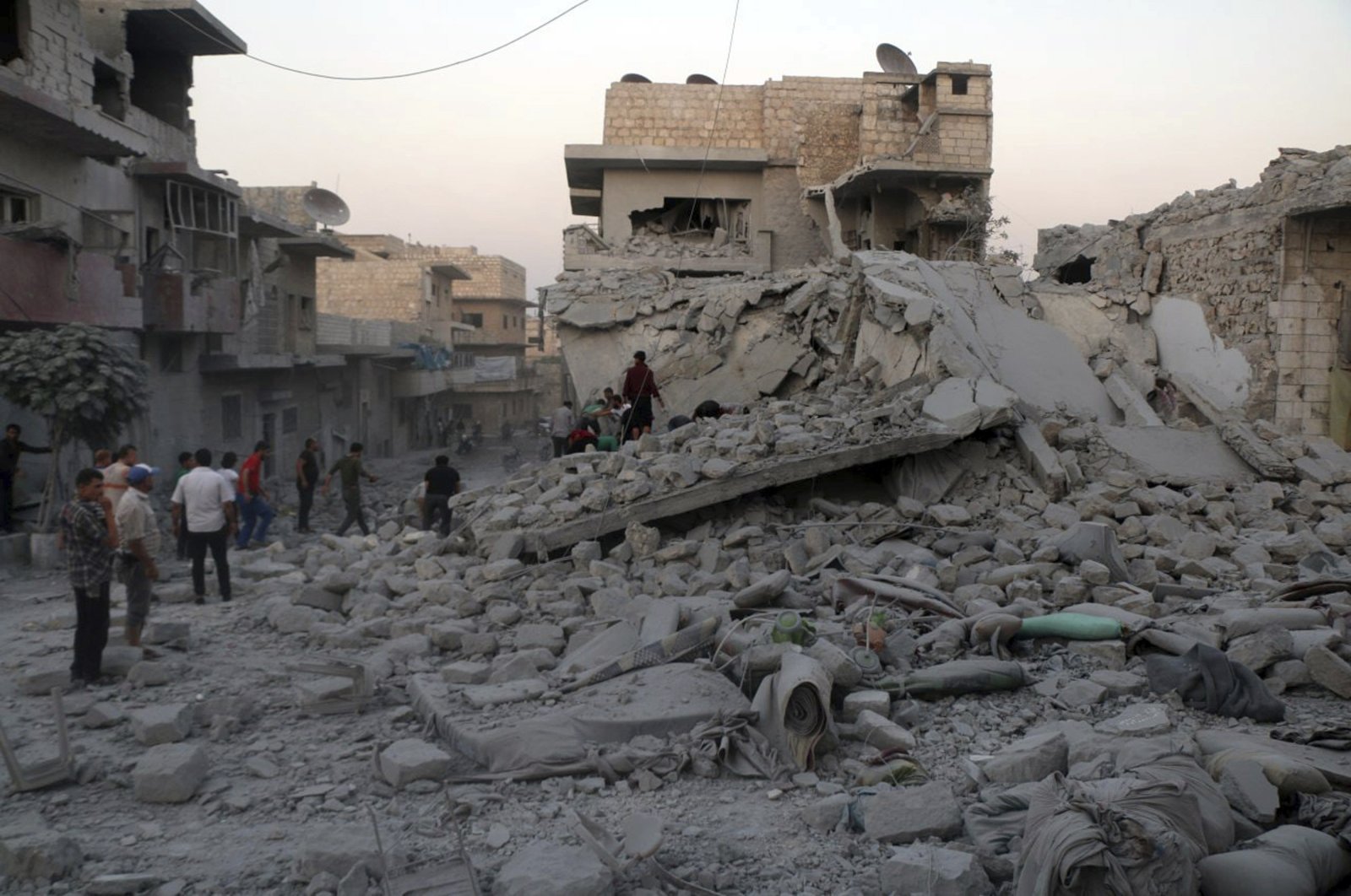 People search for victims under the rubble of destroyed buildings that were hit by regime airstrikes in the northern town of Maaret al-Numan, in Idlib province, Syria, Aug. 28, 2019. (AP Photo)