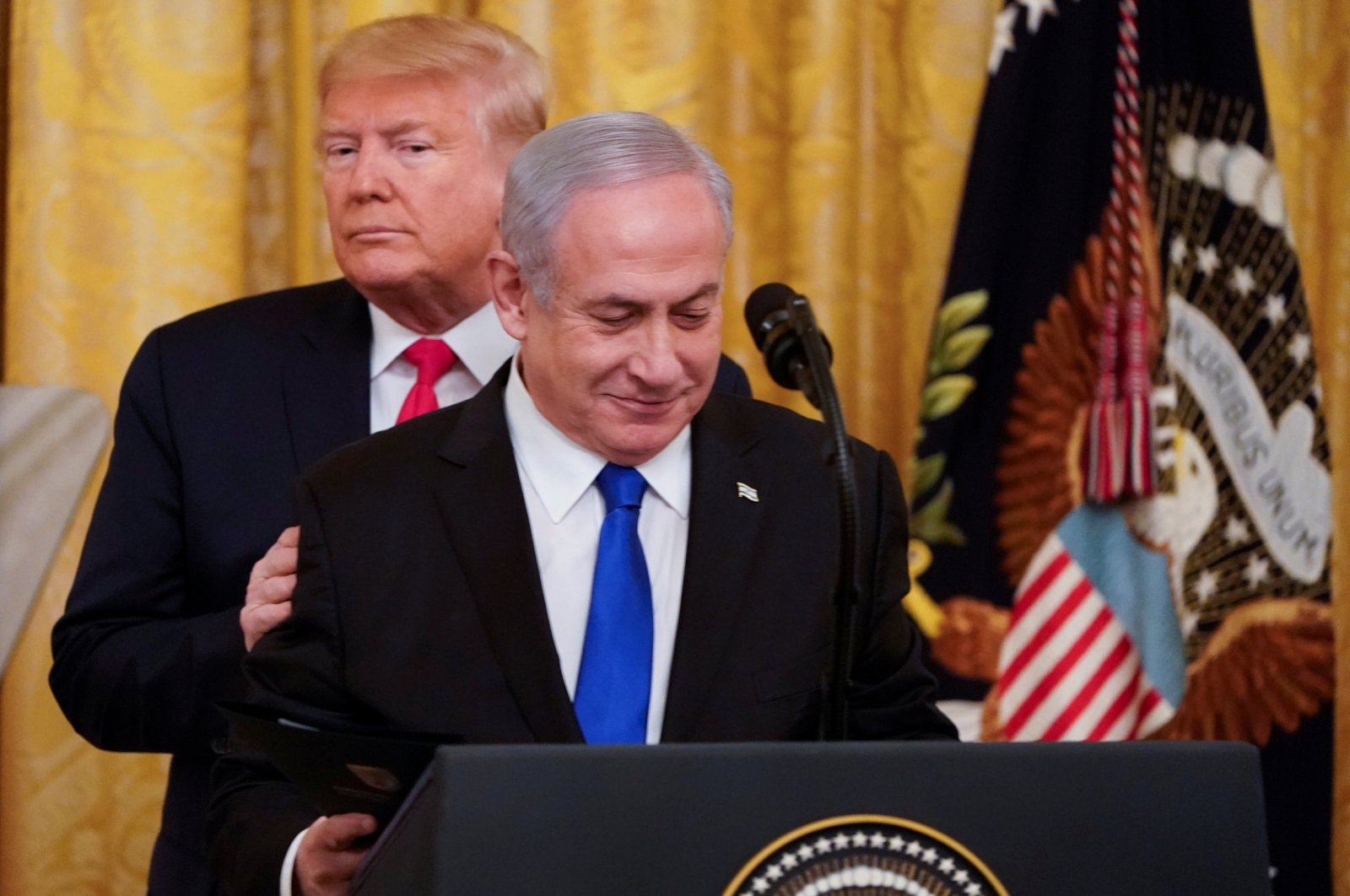 U.S. President Donald Trump puts his hands on Israel's Prime Minister Benjamin Netanyahu's shoulders as they deliver joint remarks on a Middle East peace plan proposal in the East Room of the White House, Washington, D.C., U.S., Jan. 28, 2020. (REUTERS Photo)