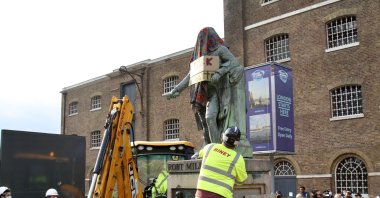 Workers remove the statue of Robert Milligan located outside the Museum of London Docklands near Canary Wharf, following the death of George Floyd who died in police custody in Minneapolis, London, Britain, June 9, 2020. (AA Photo)