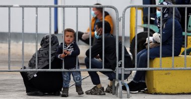 A boy looks through a metal barrier as migrants from the Moria camp wait to board a ferry that will transfer them to the mainland as a precaution against the coronavirus spread, on the island of Lesbos, Greece, May 3, 2020. (Reuters Photo)