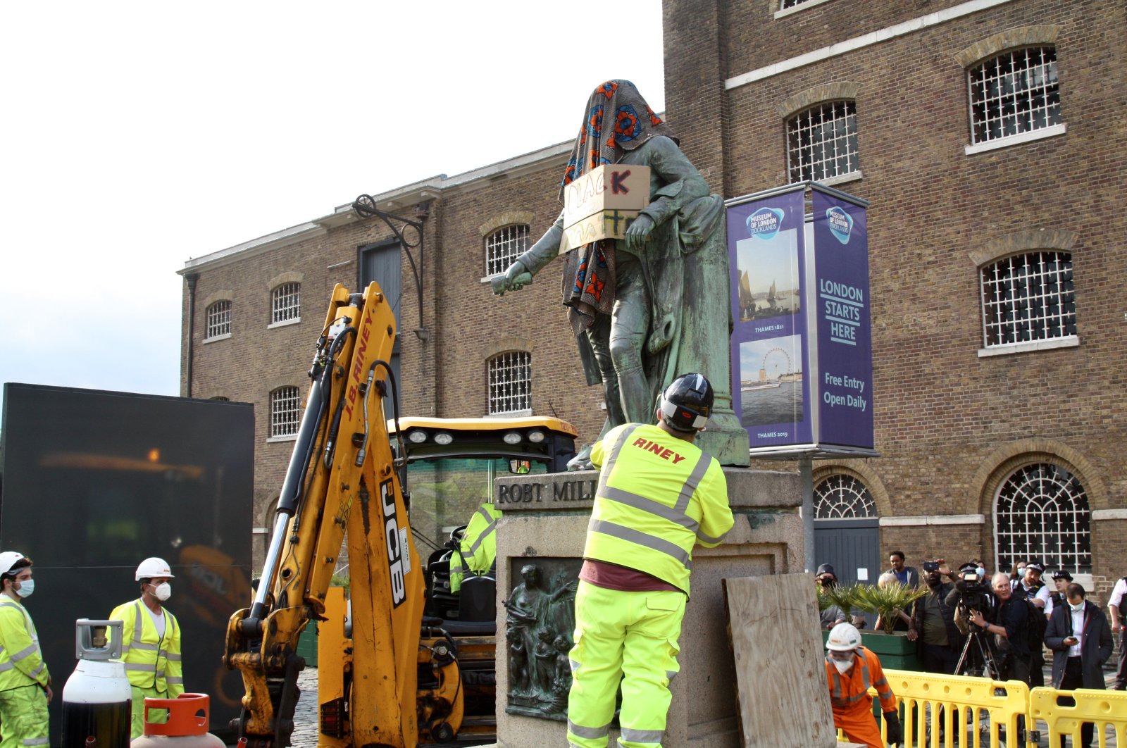 Workers remove the statue of Robert Milligan located outside the Museum of London Docklands near Canary Wharf, following the death of George Floyd who died in police custody in Minneapolis, London, Britain, June 9, 2020. (AA Photo)