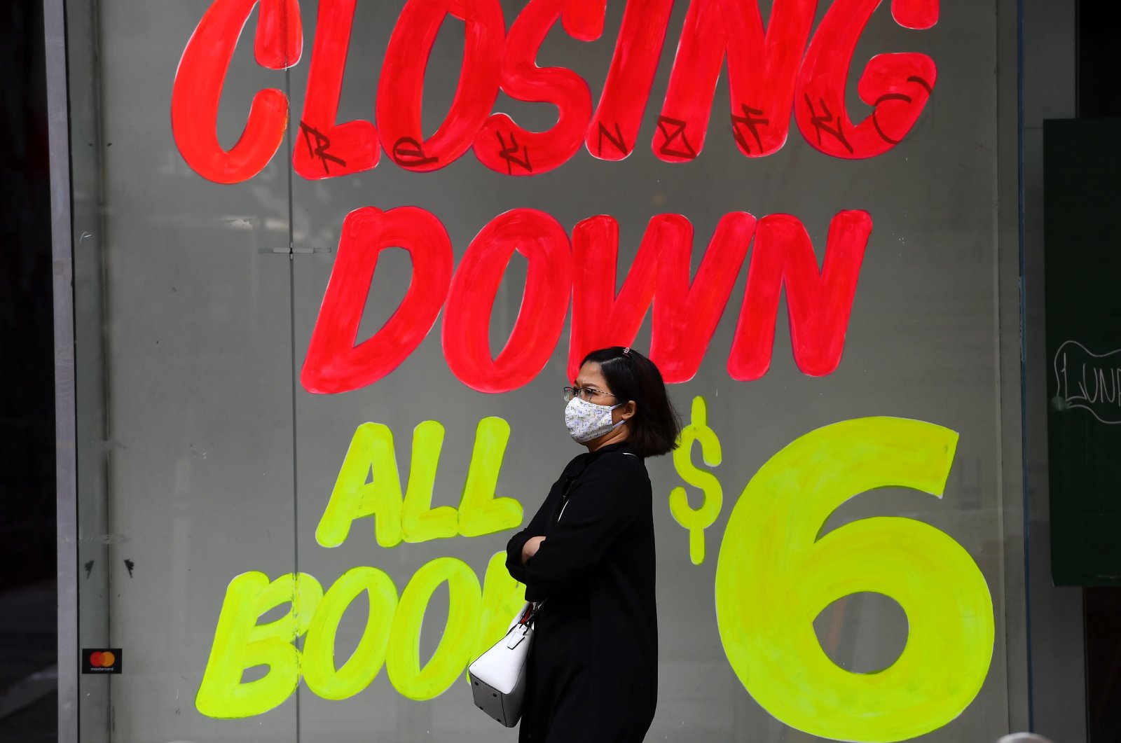 A woman walks past an empty shop in Melbourne's central business district, June 3, 2020. (AFP Photo)