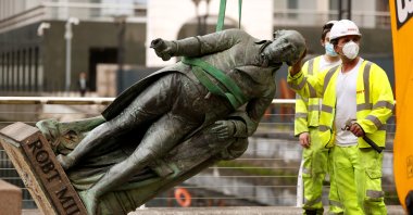 A statue of Robert Milligan is removed by workers outside the Museum of London Docklands near Canary Wharf, following the death of George Floyd, London, June 9, 2020. (Reuters Photo)