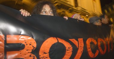French demonstrators and supporters of the BDS movement hold a placard with the word "Boycott" during a demonstration in Paris, France, Oct. 31, 2012. (AP Photo)