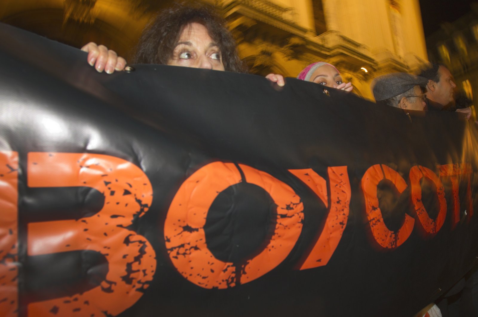 French demonstrators and supporters of the BDS movement hold a placard with the word "Boycott" during a demonstration in Paris, France, Oct. 31, 2012. (AP Photo)