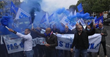 French police unionists fire blue flares as they demonstrate with a banner reading" No police, no peace" down the Champs-Elysee avenue, Paris, June 12, 2020. (AP Photo)