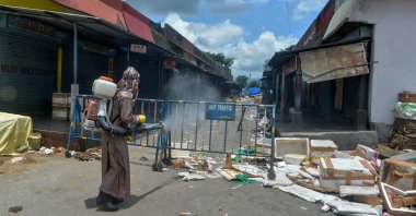 A municipal worker wearing personal protective equipment sprays disinfectant at the Siliguri Regulated Fish Market Complex, Siliguri, India, June 12, 2020. (AFP Photo)