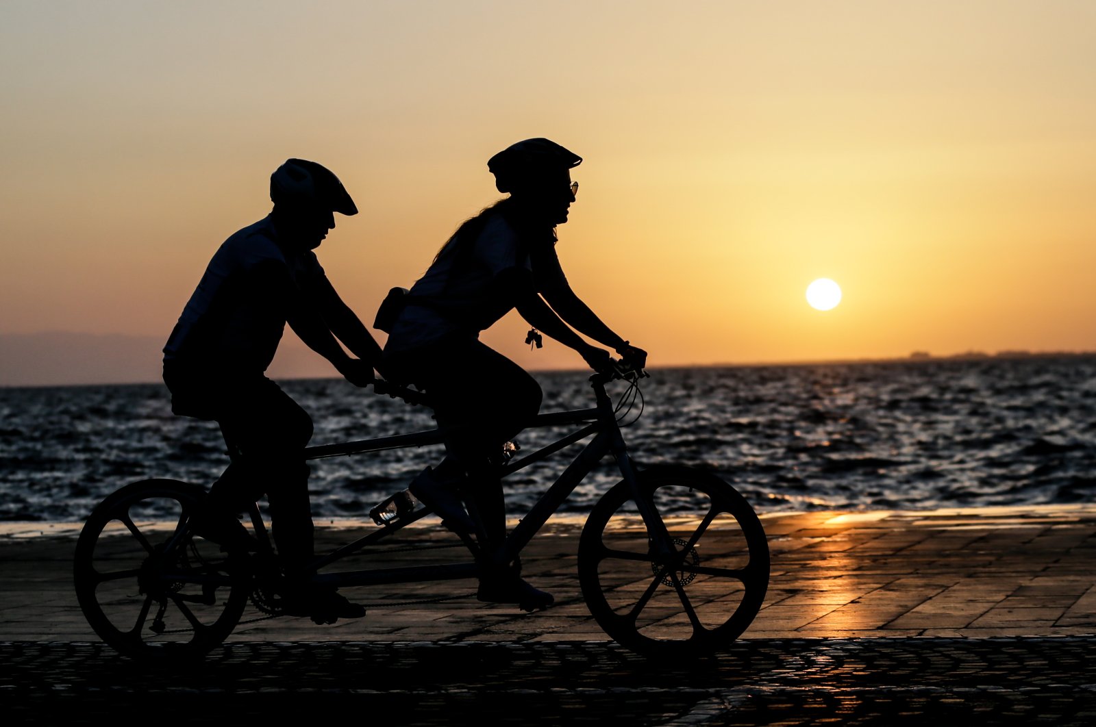 People bike along the Aegean Sea at sunset on the promenade in Izmir, Turkey, June 7, 2020. (AA Photo)