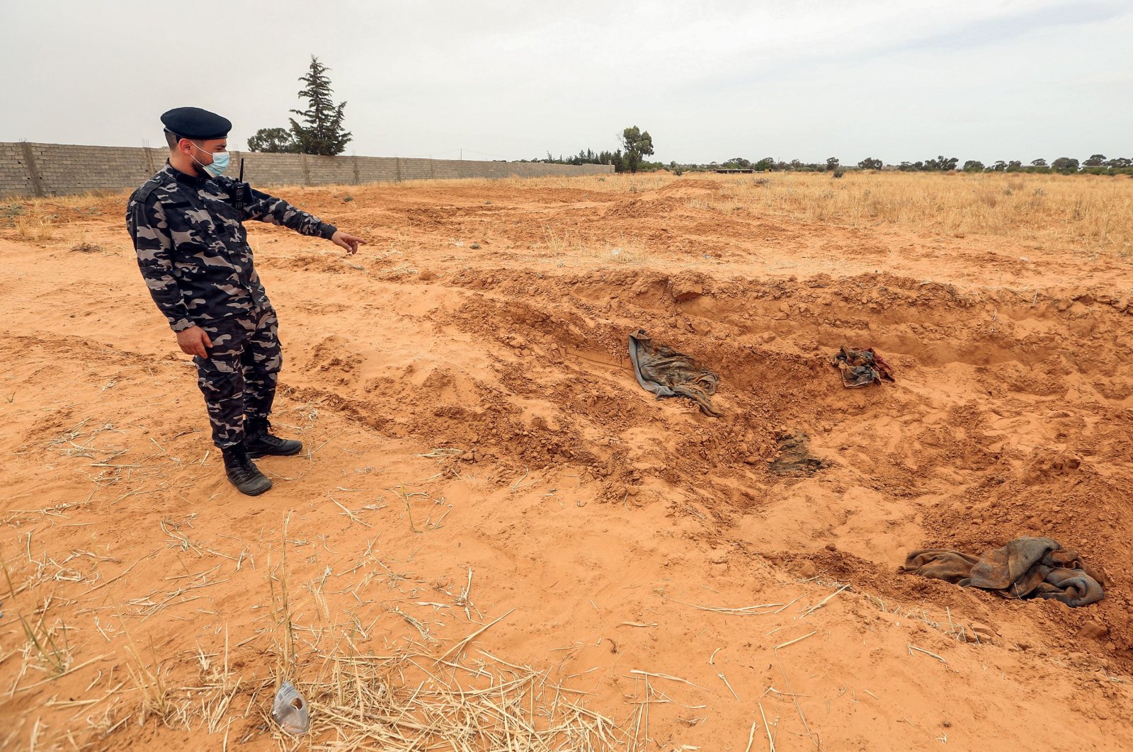 A member of security forces affiliated with the Libyan Government of National Accord (GNA)'s Interior Ministry stands at the reported site of a mass grave in the town of Tarhuna, June 11, 2020. (AFP Photo)