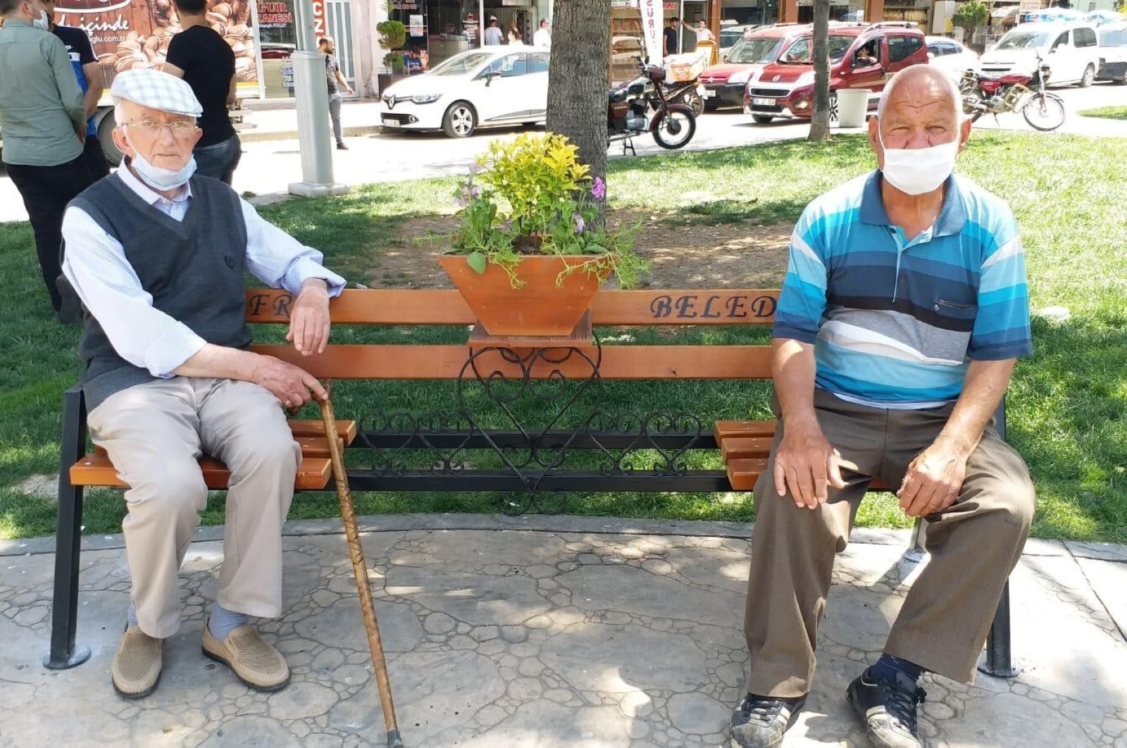 Two men sit on a "social distancing" bench in a park in Bafra district, in Samsun, Turkey, June 12, 2020. (İHA Photo)