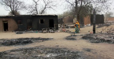 This file photo shows a woman walking past burnt houses after a two-day clash between officers of the Joint Task Force and members of Boko Haram, in Baga, Borno state, Nigeria, April 21, 2013. (AFP Photo)