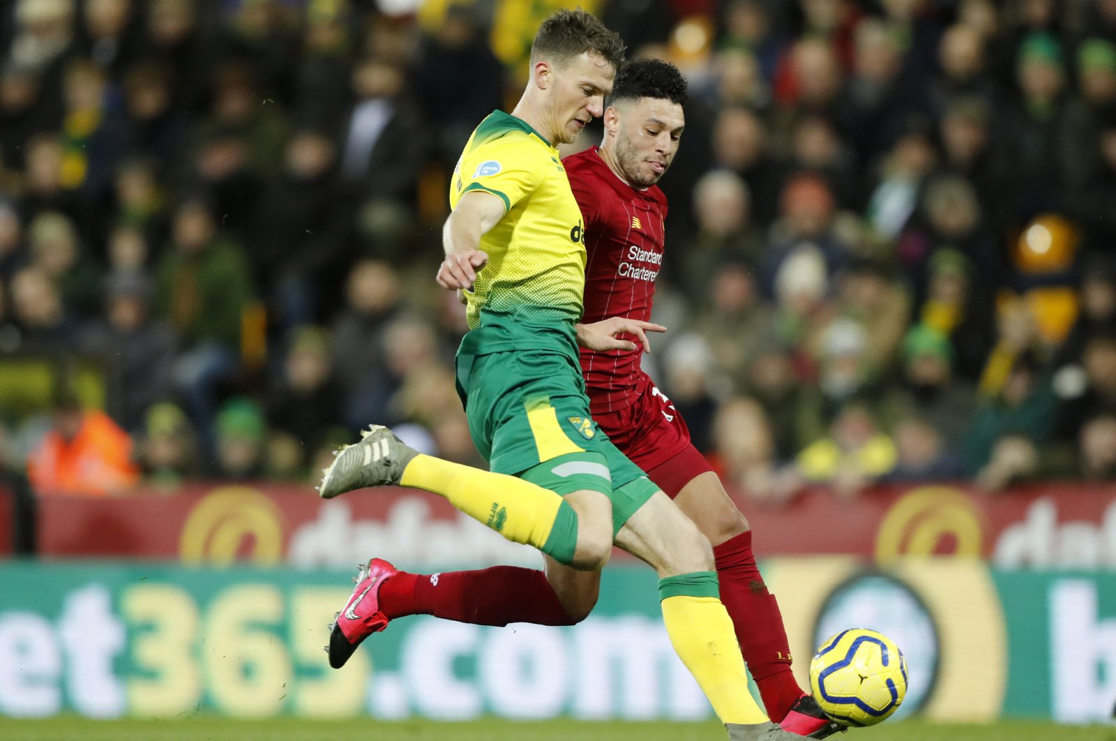 Norwich City's Max Aarons, front, duels for the ball with Liverpool's Alex Oxlade-Chamberlain during a Premier League match in Norwich, England, Feb. 15, 2020. (AP Photo)