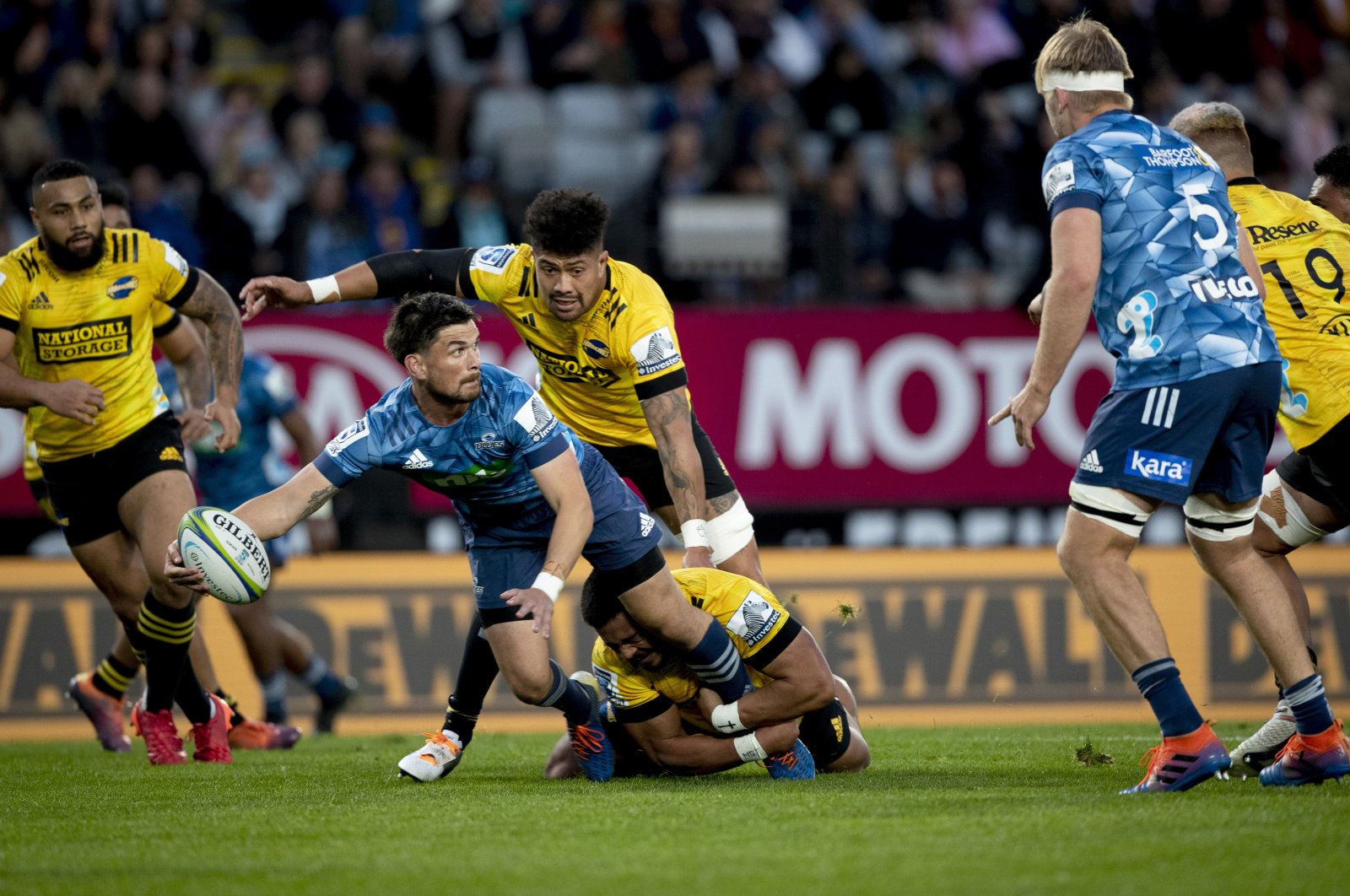Auckland Blues Blues player Otere Black (C) looks to pass the ball to a teammate during the Super Rugby Aotearoa rugby match between the Blues and the Hurricanes at Eden Park, in Auckland, New Zealand, June 14, 2020. (New Zealand Herald via AP Photo)