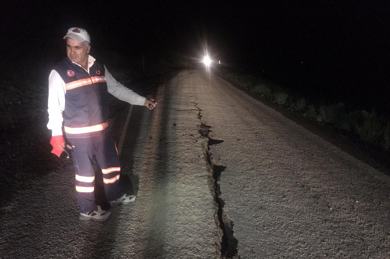 A Disaster and Emergency Management Authority (AFAD) employee stands by a crack that emerged in a road following a 5.7 magnitude earthquake, Bingöl, Turkey, June 14, 2020. (AA Photo)