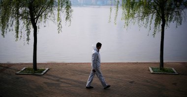 A man wearing protective gear walks by the Yangtze river in Wuhan, Hubei province, China, April 4, 2020. (Reuters Photo)