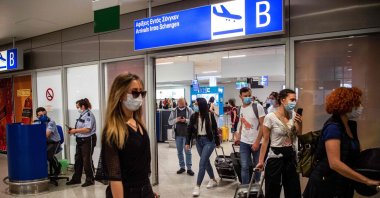Passengers of a flight from Paris wearing protective face masks arrive at the Eleftherios Venizelos International Airport in Athens, June 15, 2020. (AFP Photo)