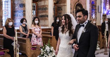 Newlyweds Iskender and Melek Acar walk to the altar as the only people in the church not wearing masks, in Istanbul, Turkey, June 14, 2020. (DHA Photo)