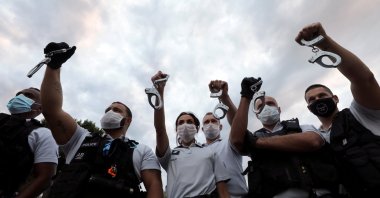 Police officers hold handcuffs in the air during a protest against French Interior Minister Christophe Castaner's reforms, including ditching a controversial chokehold method of arrest, Nice, France June 12, 2020. (Reuters Photo)