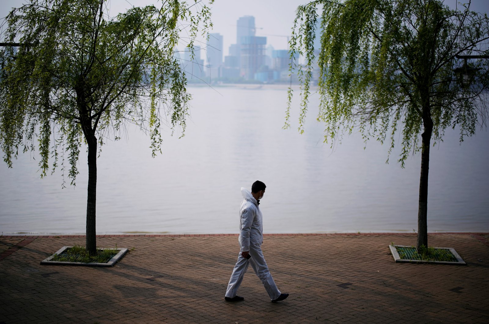 A man wearing protective gear walks by the Yangtze river in Wuhan, Hubei province, China, April 4, 2020. (Reuters Photo)