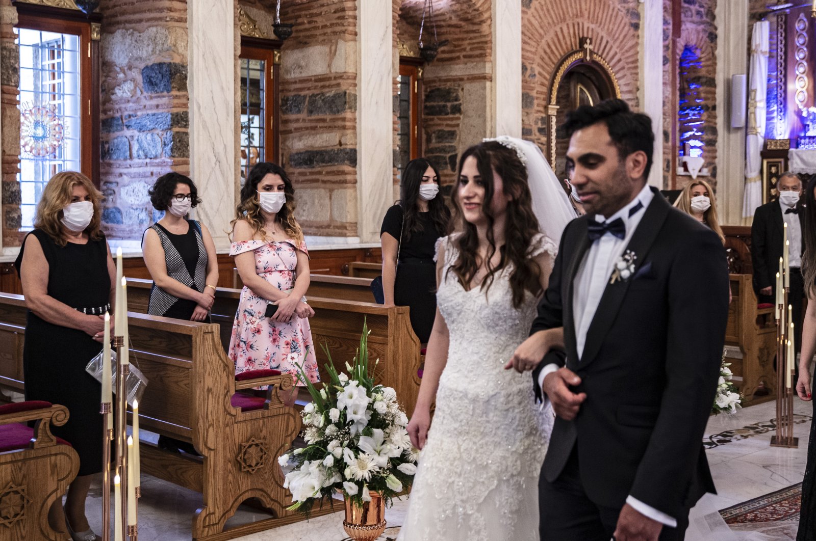 Newlyweds Iskender and Melek Acar walk to the altar as the only people in the church not wearing masks, in Istanbul, Turkey, June 14, 2020. (DHA Photo)
