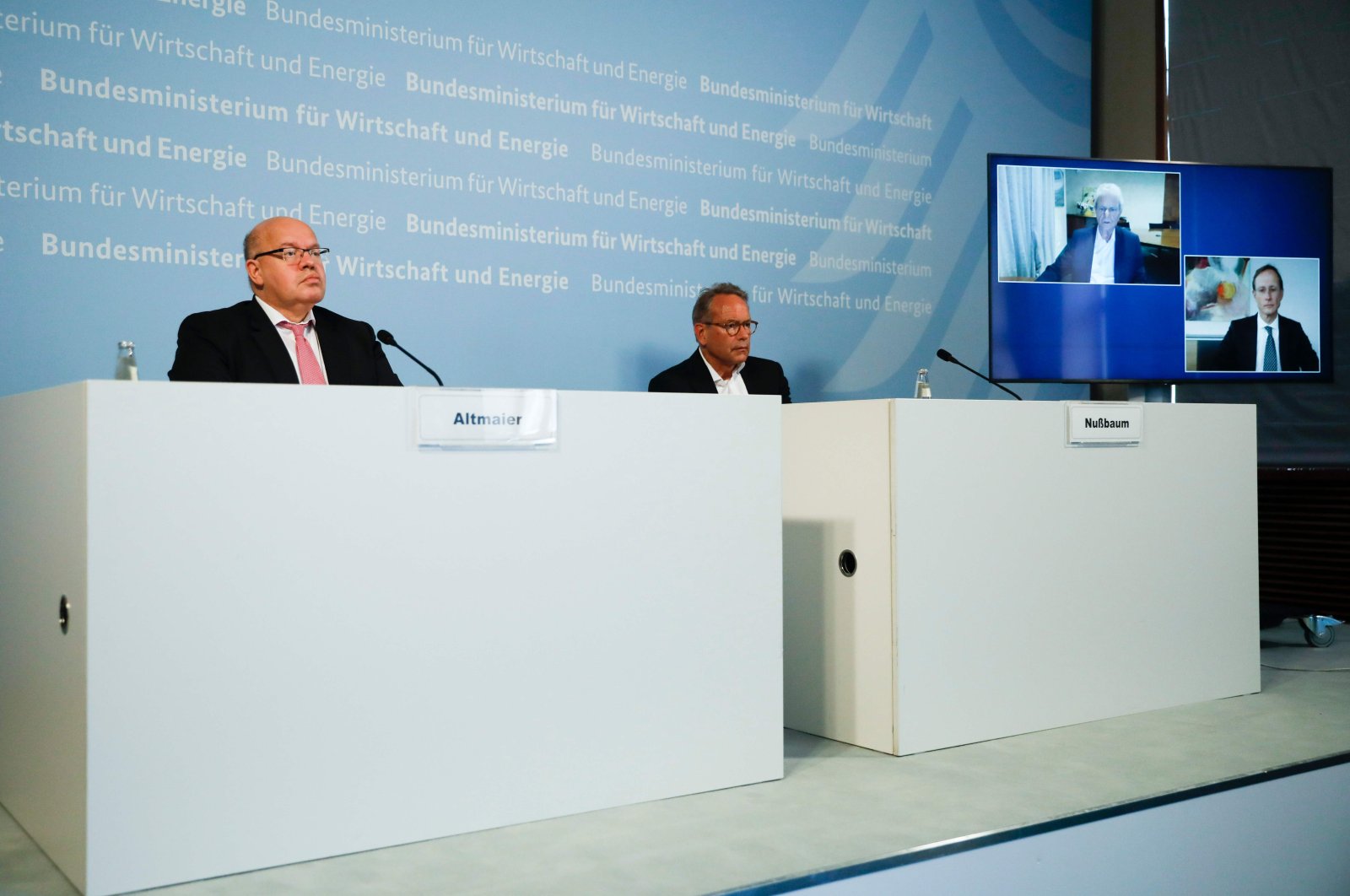 German Economy Minister Peter Altmaier (L), and state secretary at the economic ministry Ulrich Nussbaum (R) attend a news conference with CureVac main shareholder Dietmar Hopp (on the screen left) at the economy ministry in Berlin, June 15, 2020. (AFP Photo)