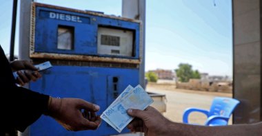 A Syrian man pays with Turkish liras at a gas station in the town of Sarmada in Syria's northwestern Idlib province, June 15, 2020. (AFP Photo)