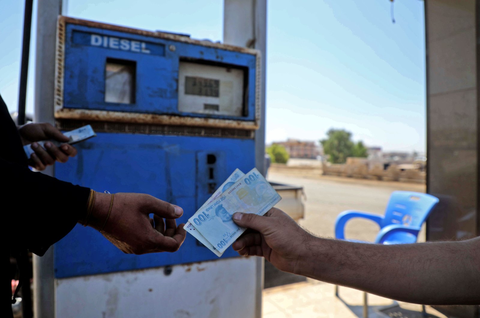A Syrian man pays with Turkish liras at a gas station in the town of Sarmada in Syria's northwestern Idlib province, June 15, 2020. (AFP Photo)