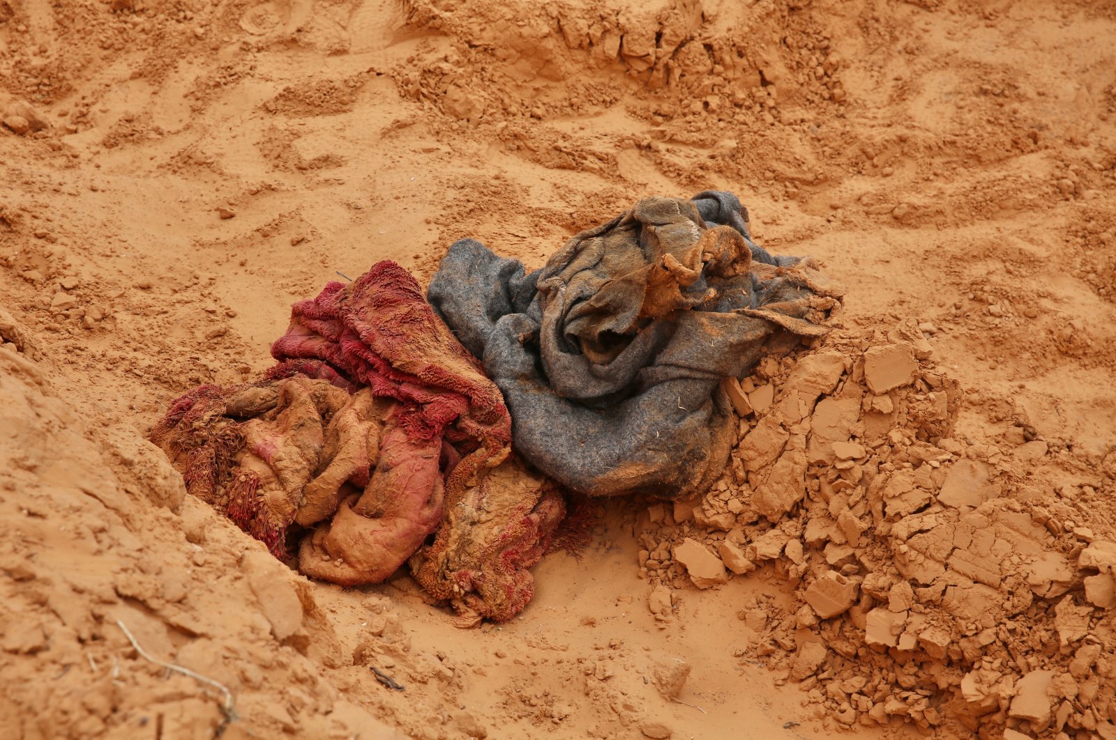 Scraps of clothing were scattered around the site near mass graves covered with fresh soil in Libya's Tarhuna province, June 12, 2020. (AA Photo)