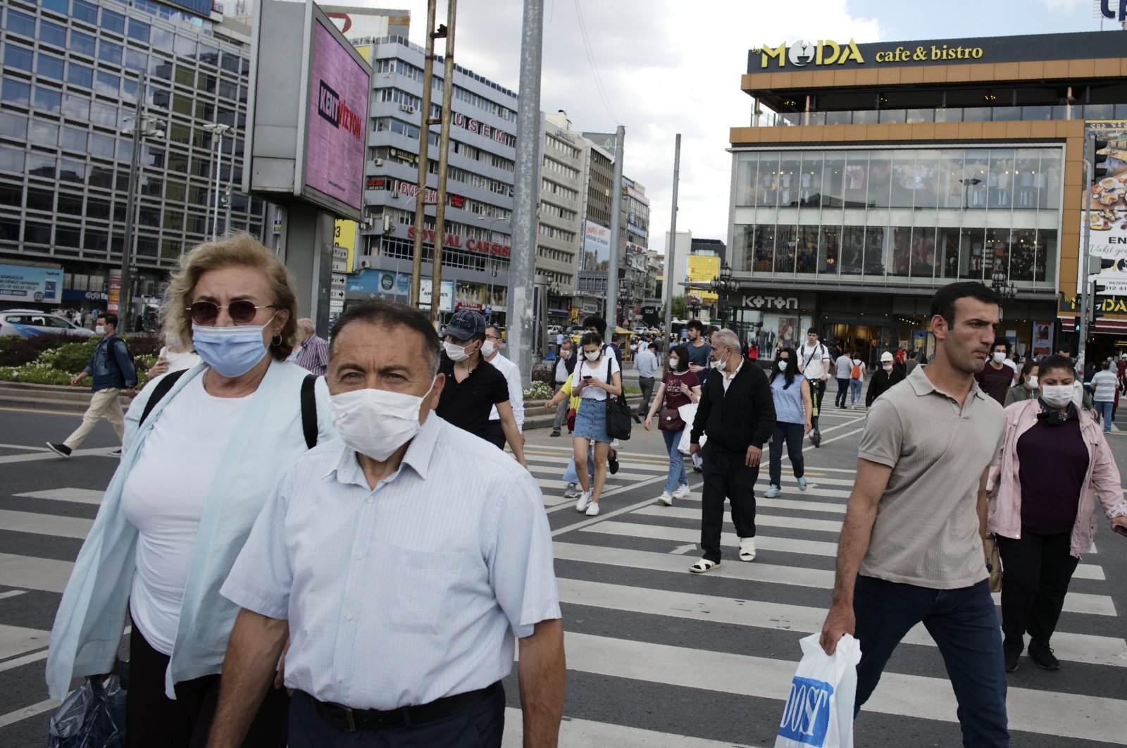 People wearing face masks to protect against the spread of coronavirus, walk in the main Kızılay Square, in Ankara, Turkey, Tuesday, June 16, 2020. (AP Photo)
