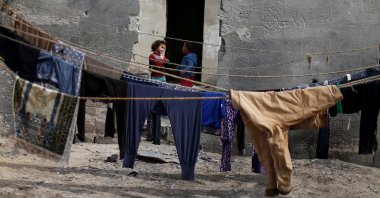 Palestinian children stand outside their house as laundry hangs on ropes at Shati refugee camp in Gaza city, Palestine, Feb. 19, 2020. (Reuters Photo)