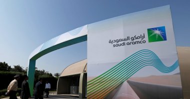 The logo of Aramco is seen as security personnel walk before the start of a press conference by Aramco at the Plaza Conference Center in Dhahran, Saudi Arabia, Nov. 3, 2019. (Reuters Photo)