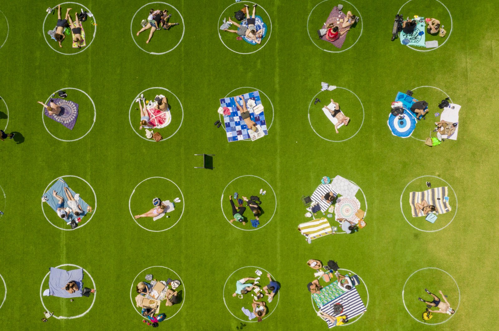 Domino Park in Brooklyn paints circles on the grass to assist visitors in maintaining social distancing, New York City, New York, U.S., May 20, 2020.  (Reuters Photo)