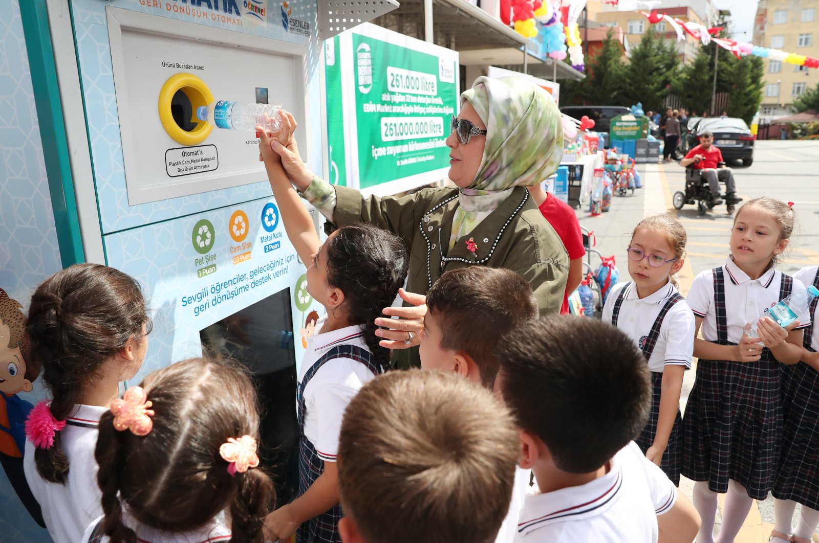 First lady Emine Erdoğan dumps a plastic bottle into a recycling bin at an event to promote the Zero Waste project among students at a school in Istanbul, Turkey, in this undated photo. (AA Photo)