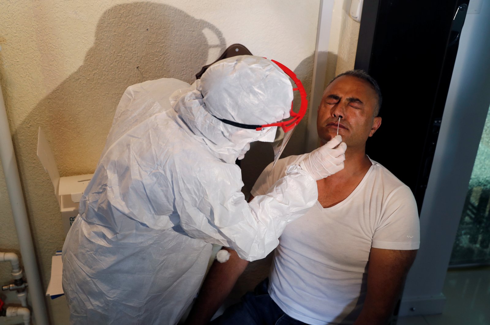 A medical worker takes a swab sample from a man during an antibody testing program against COVID-19, in Istanbul, Turkey, June 17, 2020. (REUTERS Photo) 
