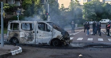Police and gendarmes stand near a burnt van in the Gresilles area of Dijon, France, June 15, 2020. (AFP Photo)